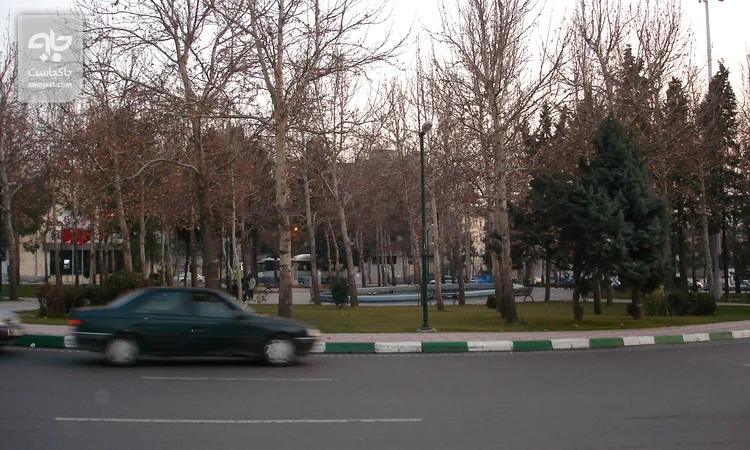 فلکه سوم تهرانپارس با درختان چنار بلند و خودروی در حال عبور در شرق تهران